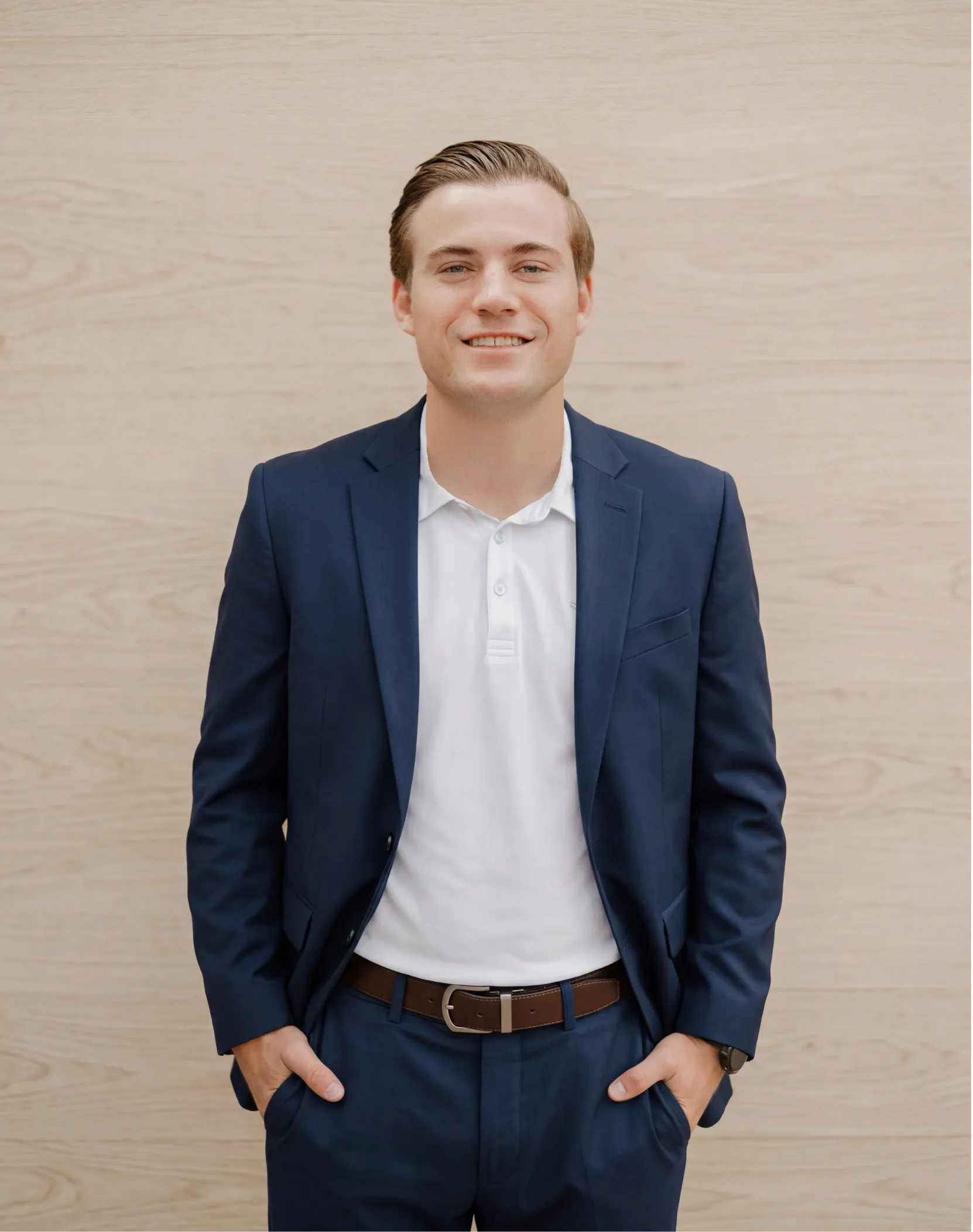 Austin Criss, REALTOR with RE/MAX Tiffany, in a navy blazer and white shirt.